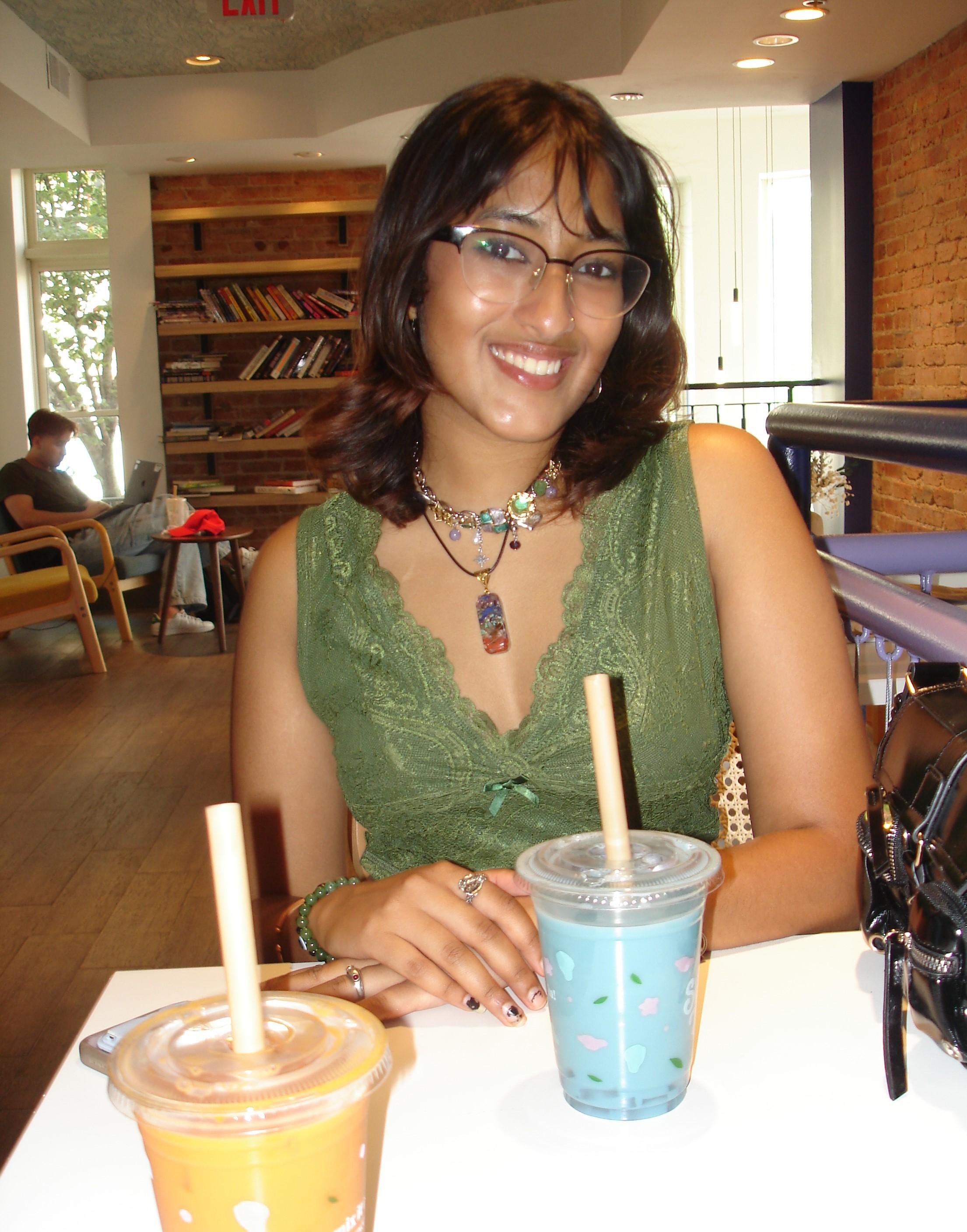 Smiling student about to enjoy a blue smoothie.