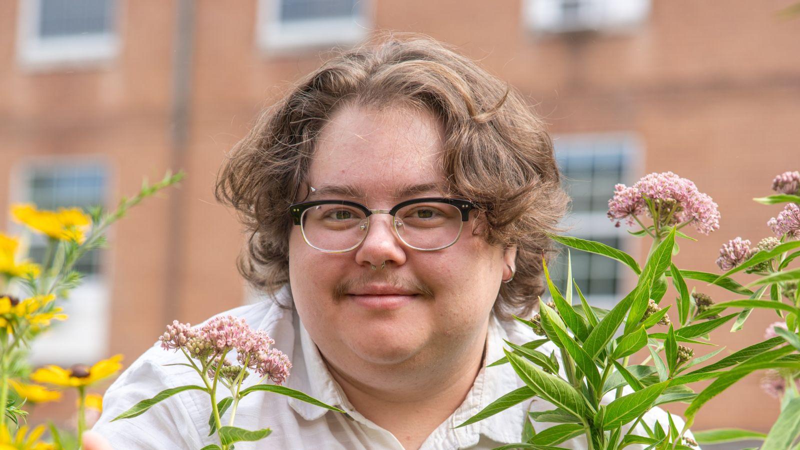 Andrew Heffner kneeling over flowers in a bird bed