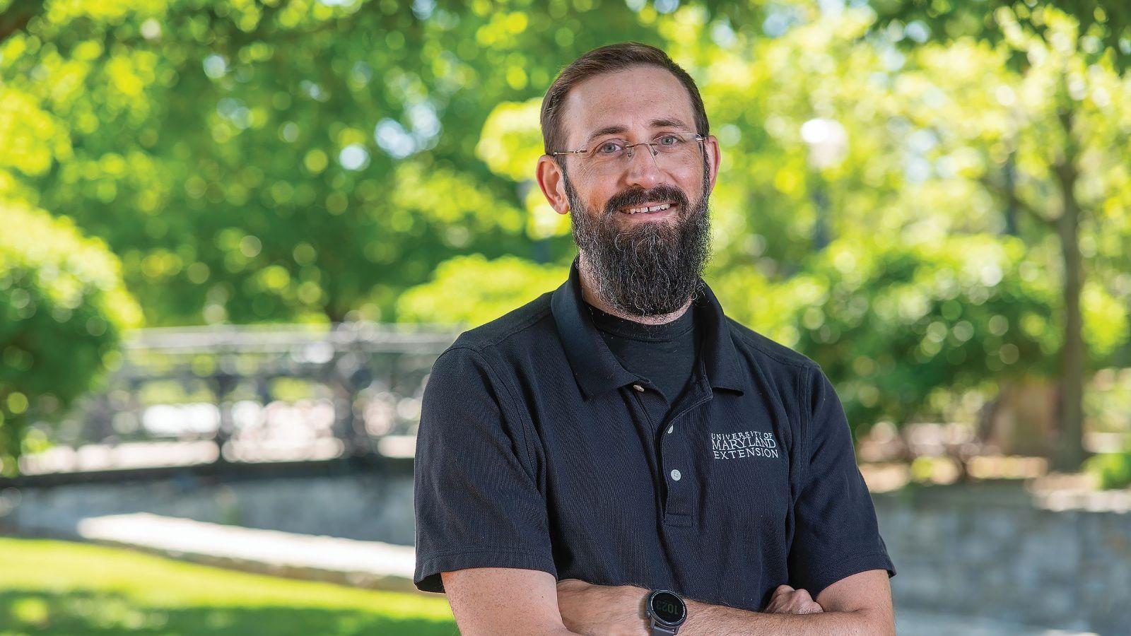 Drew Schiavone standing smiling on campus