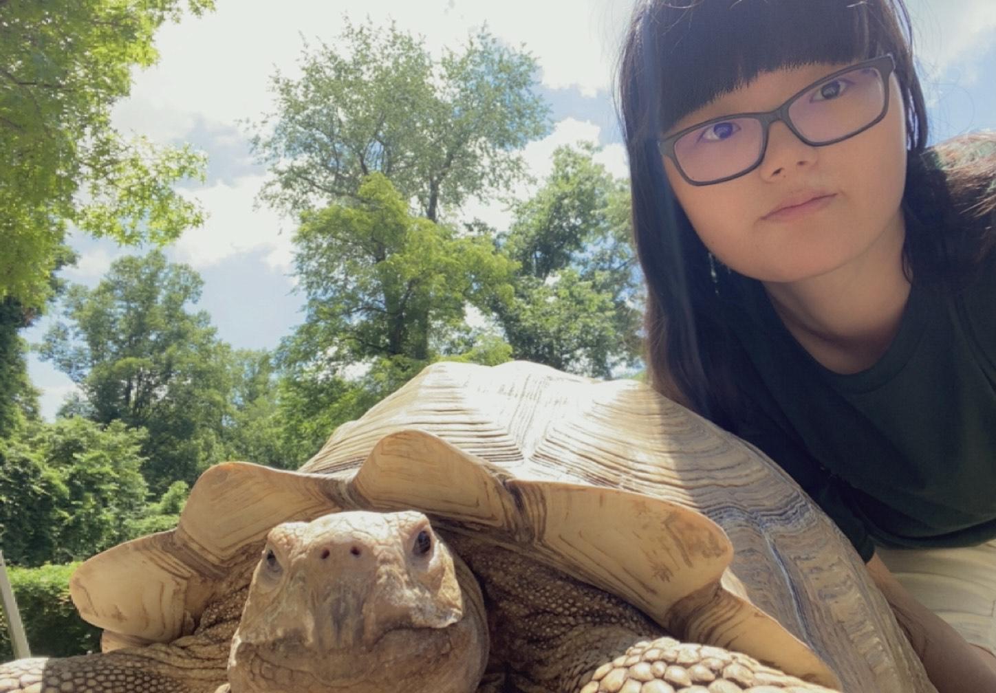 Pensive student posing with tortoise.
