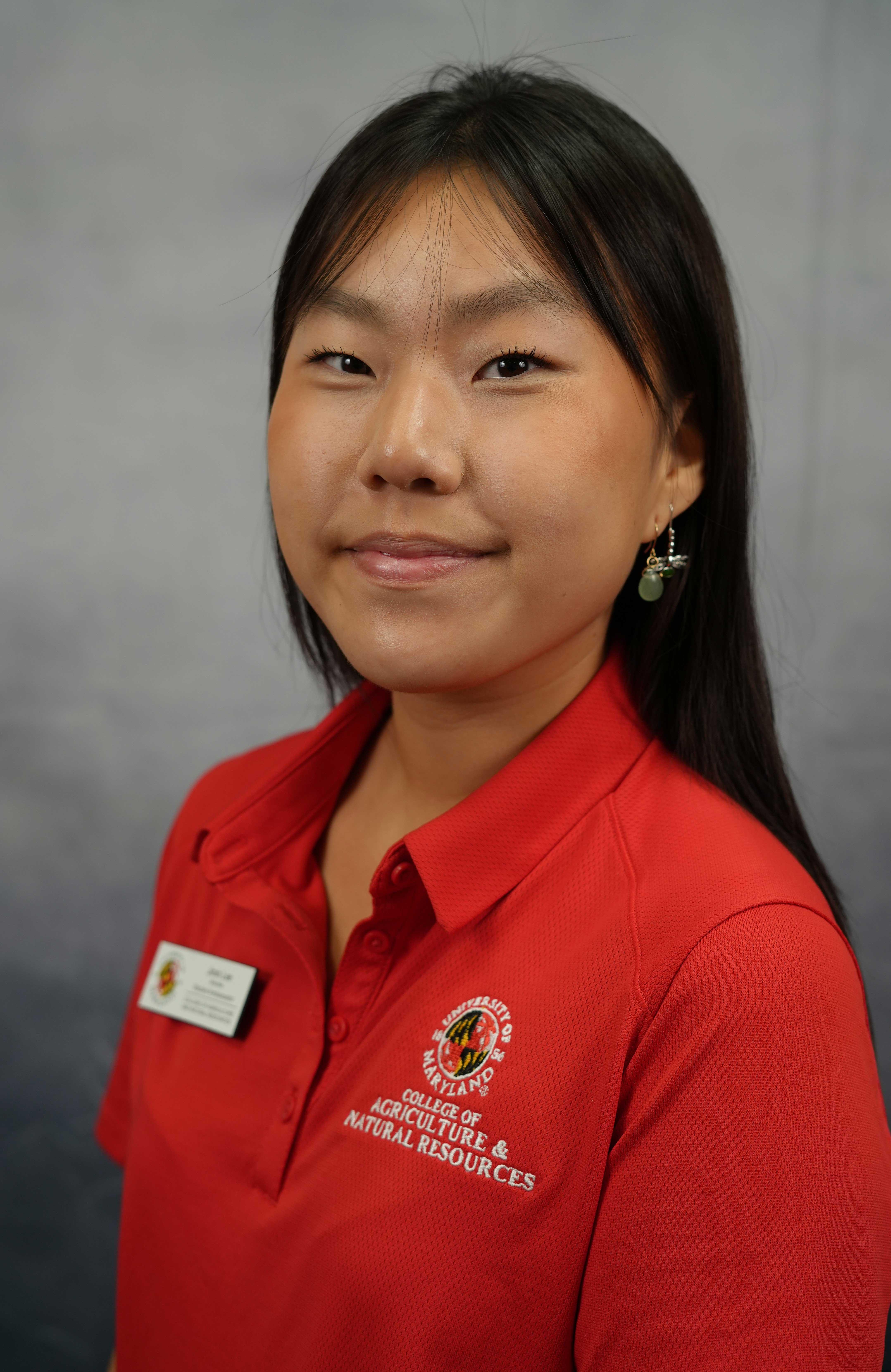 Professional image of kind-eyed student wearing red Ambassador uniform polo.