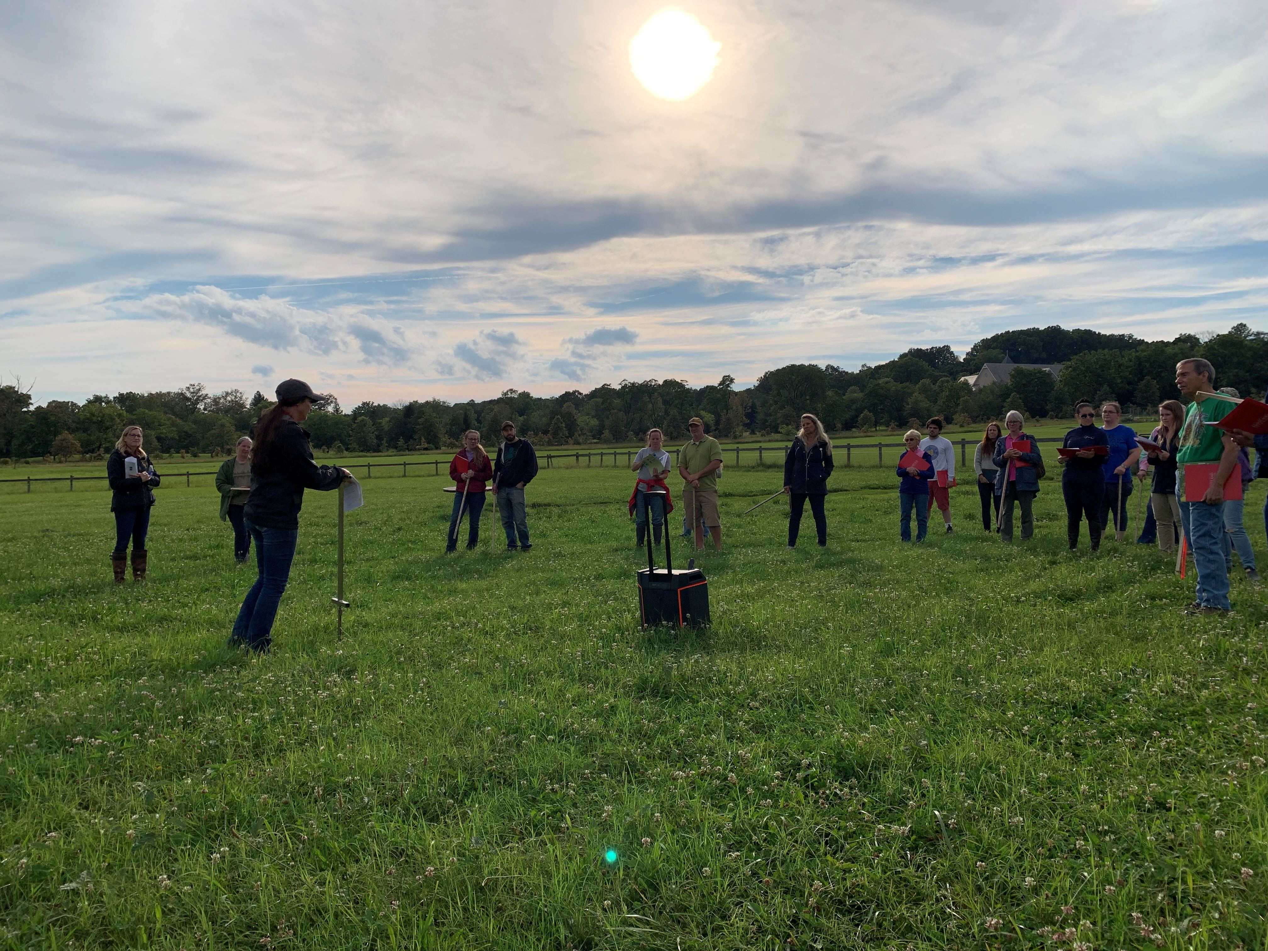 Group of farmer gathered in pasture learning about pasture management. 