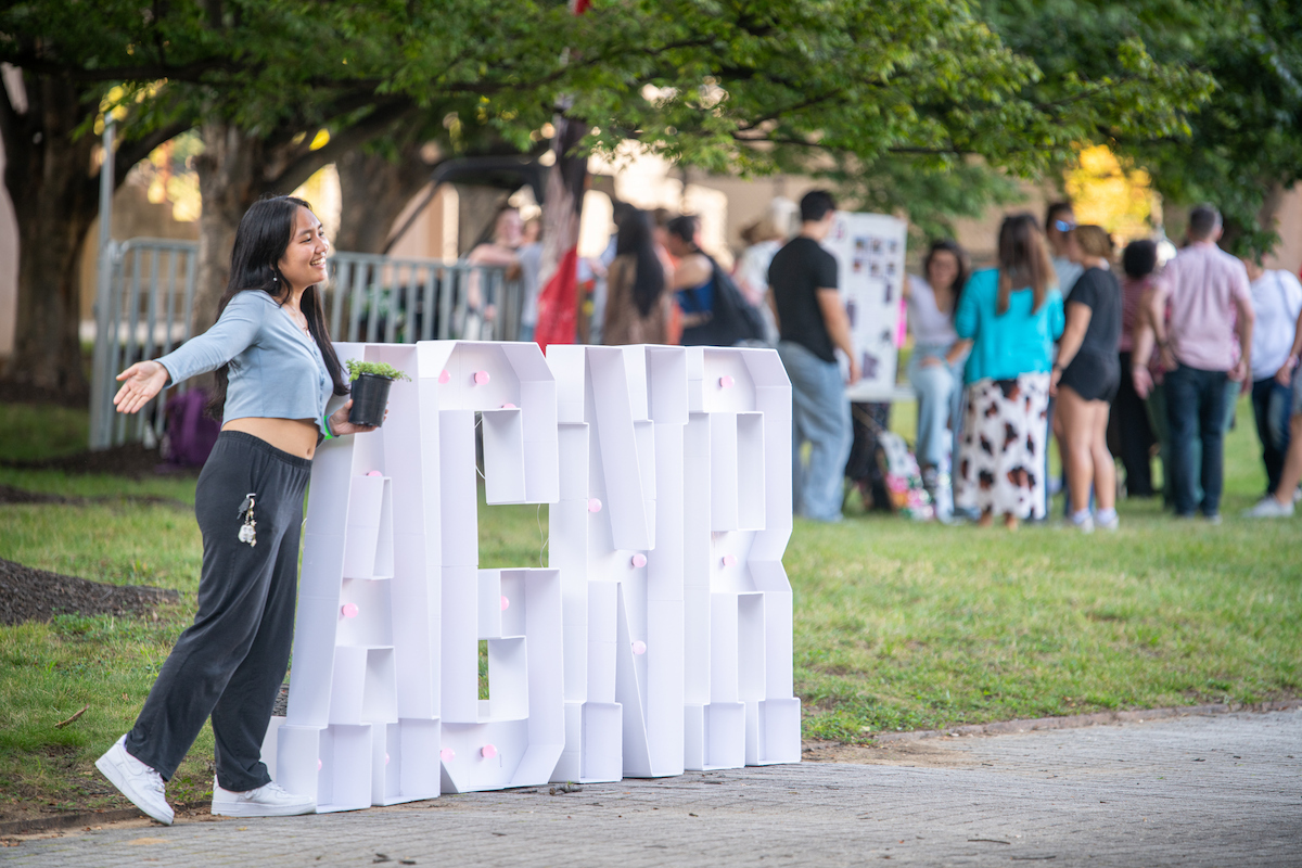 Student posing with the AGNR sign at Welcome Back Bash