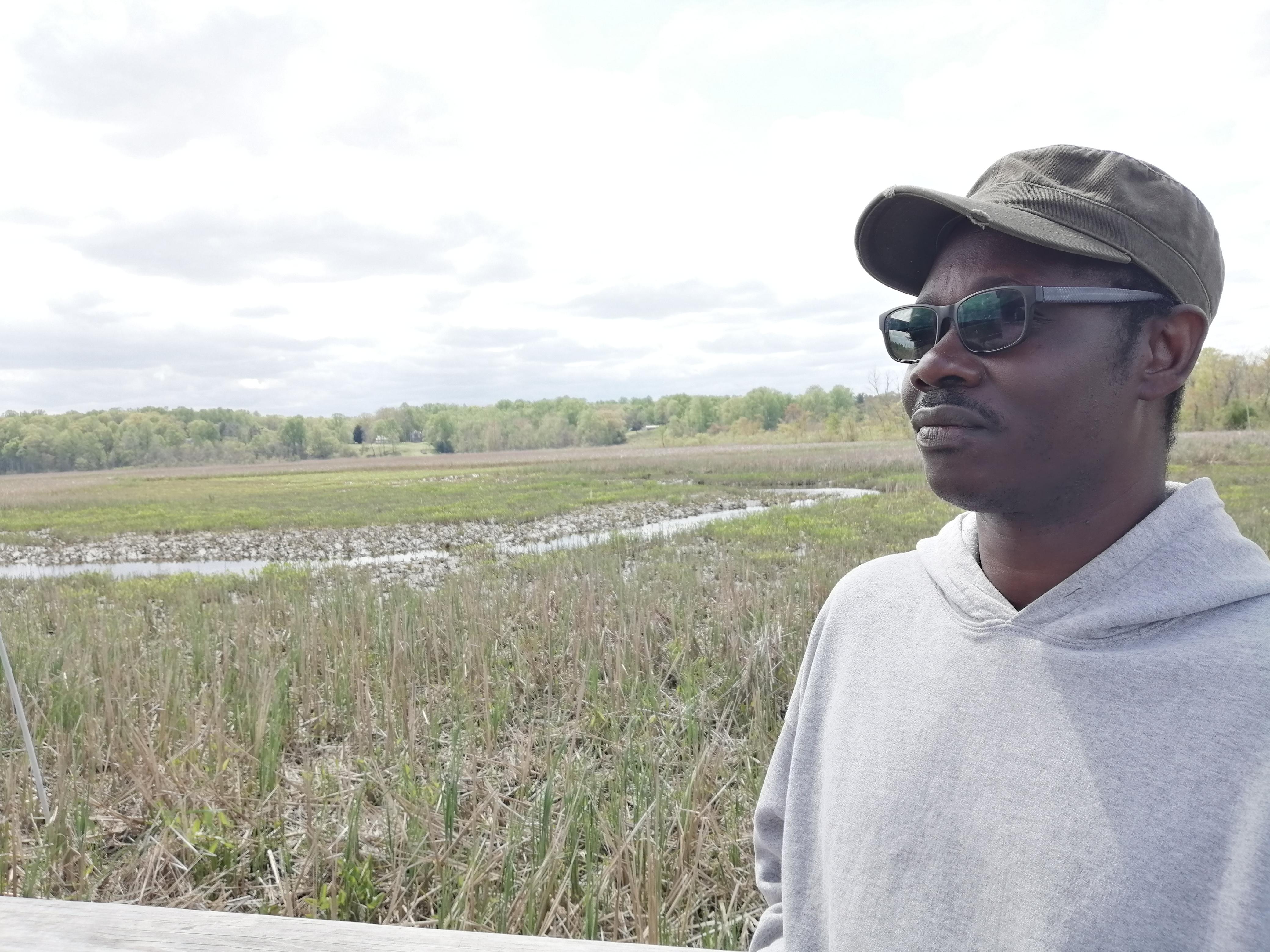 Kwesi Asante standing in green field