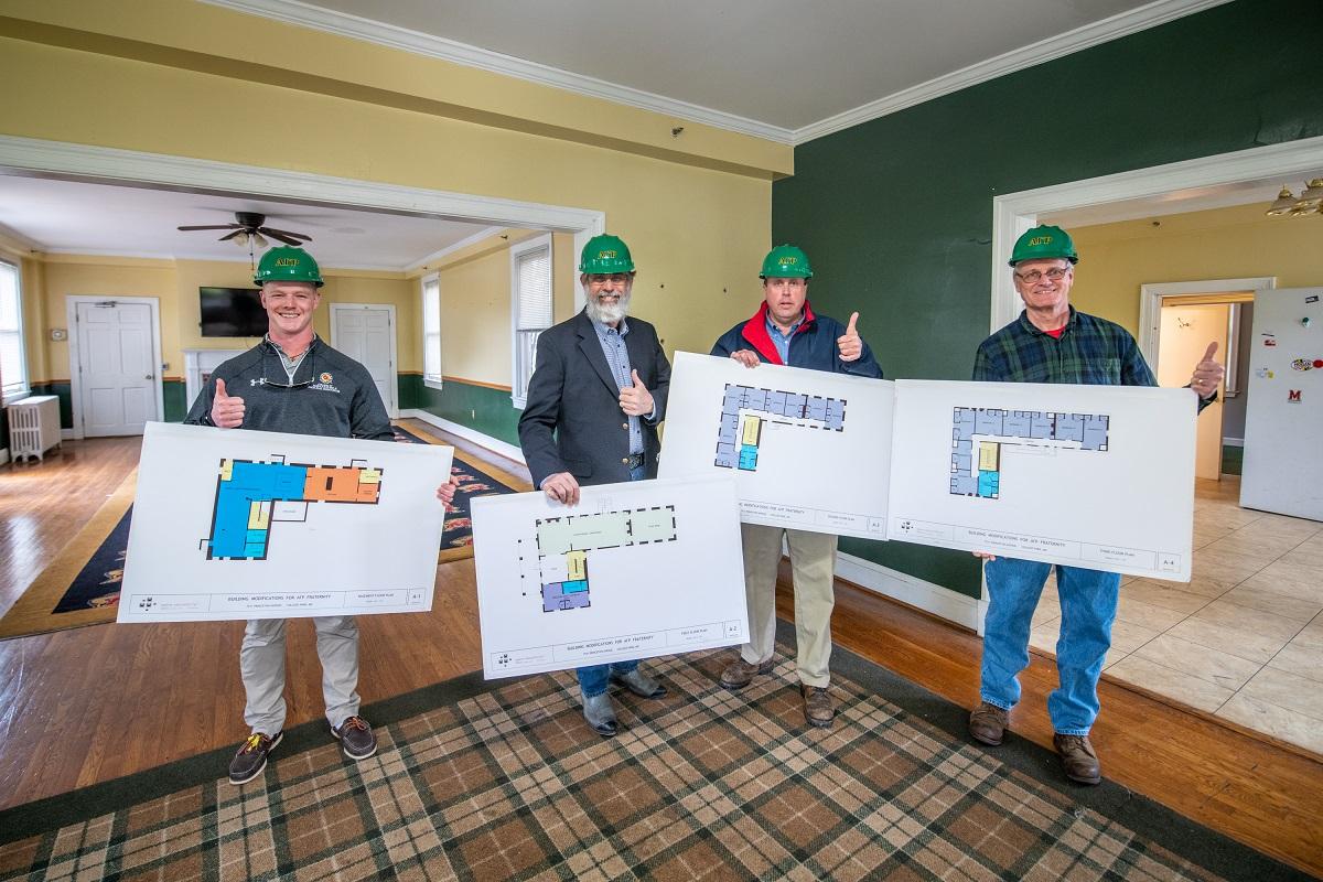 Jake Hess, Chris Cavey, Bill Allen, and Frank Allnut hold plans for the new house renovation