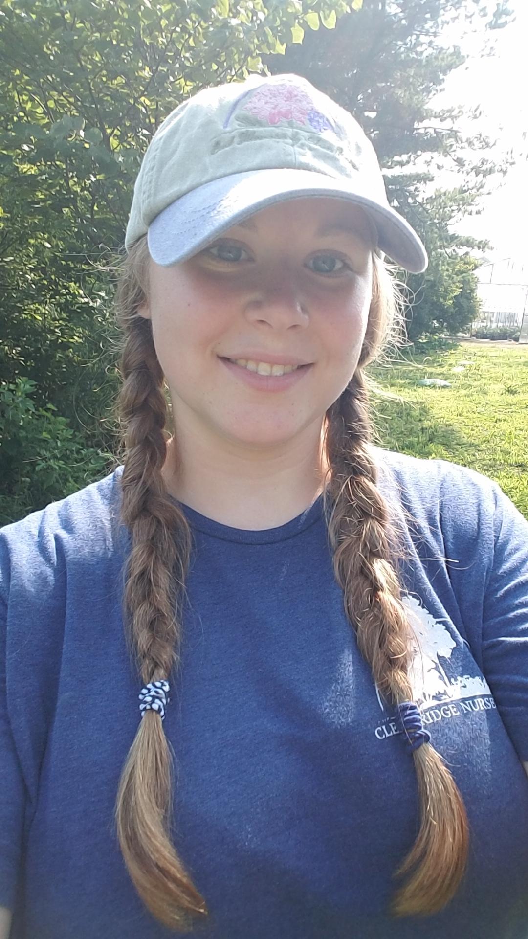 Alum Lydia Printz selfie wearing a baseball hat and a blue shirt