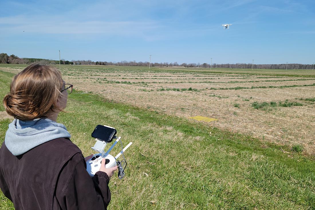 Student flying a drone at a research farm