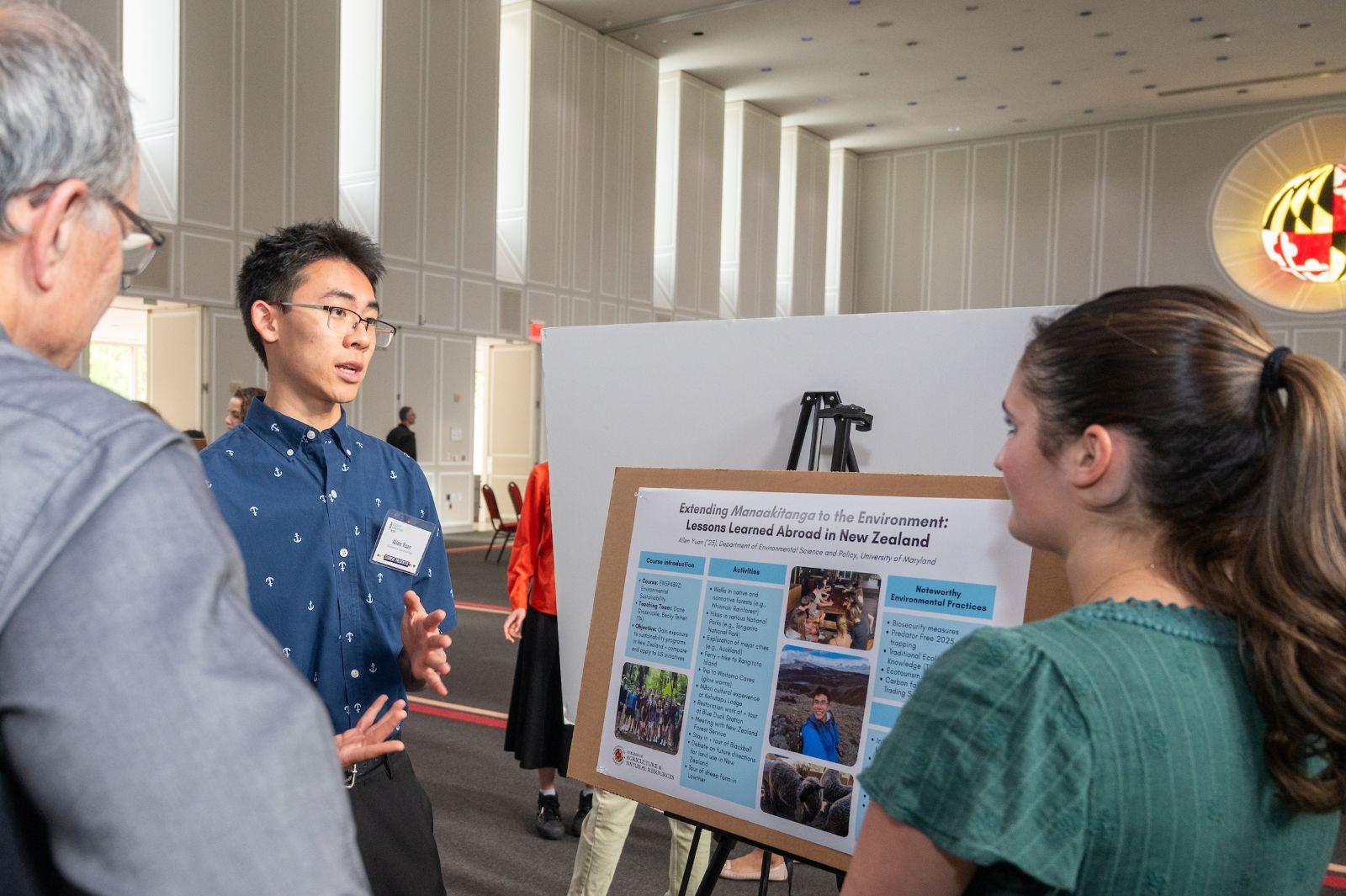 Student talking with attendees at an event