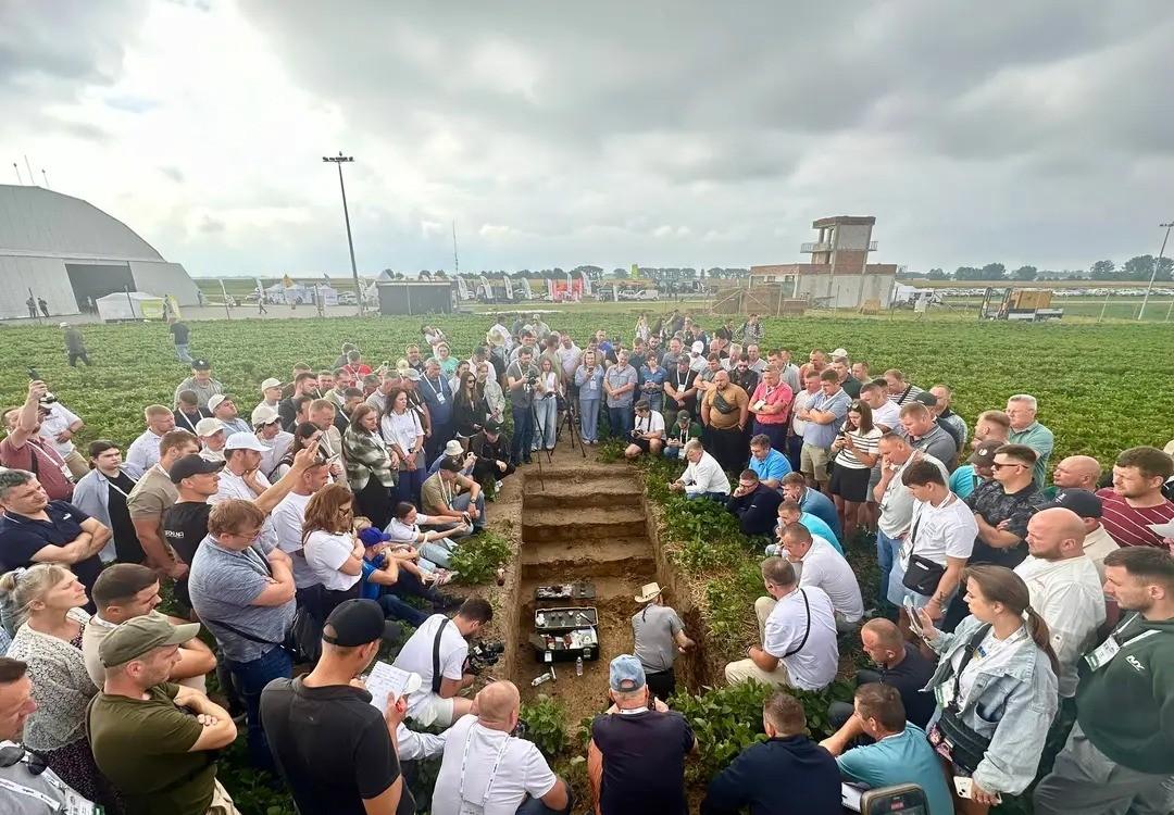 Ray Weil stands in a waste-deep soil pit with hundreds of farmers gathered around. 