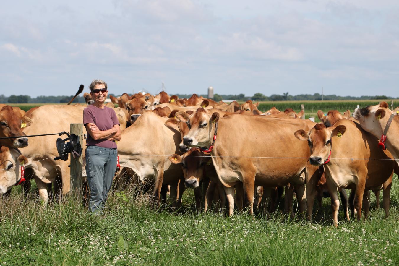 Judy Gifford stands with a herd of dairy cows