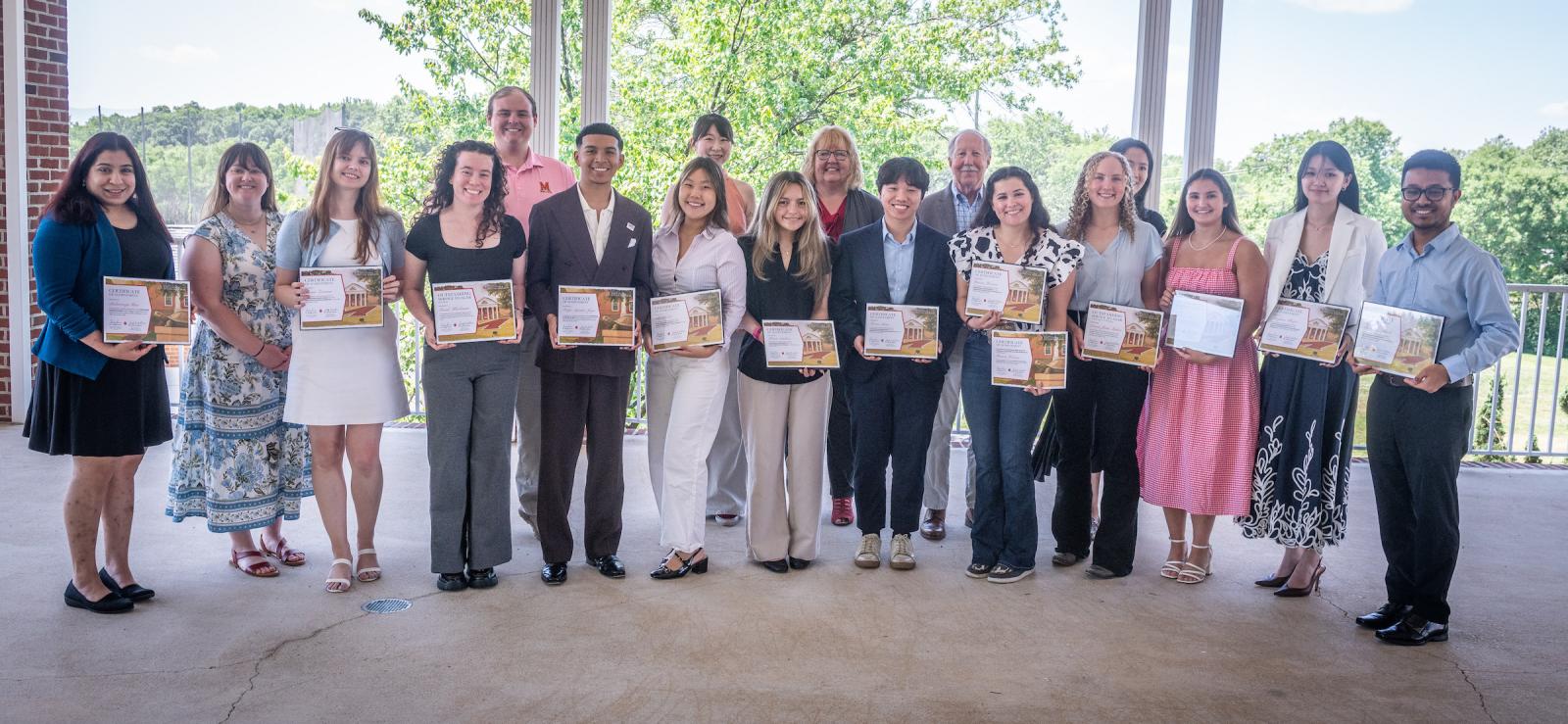 Award winners holding their certificates together w