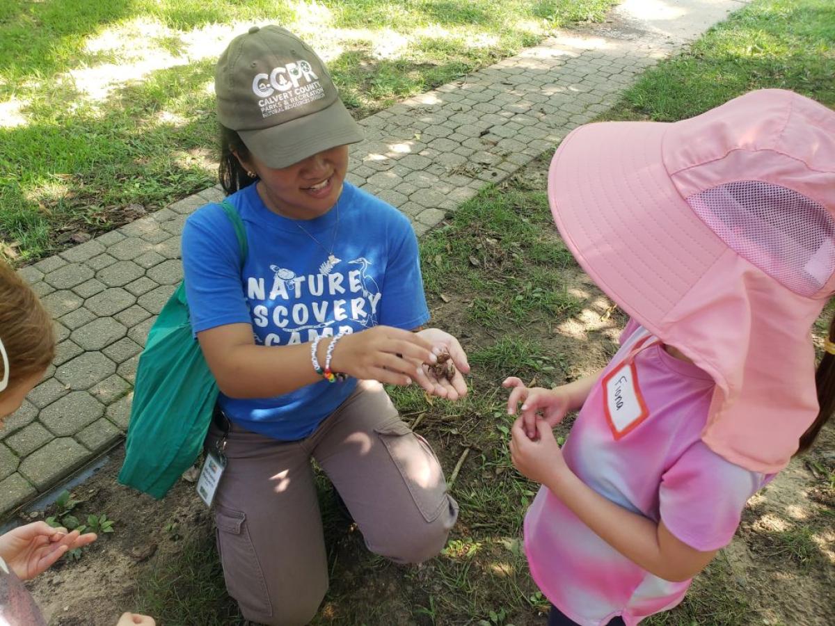 ENSP student holding an animal for a kid to see at a community event