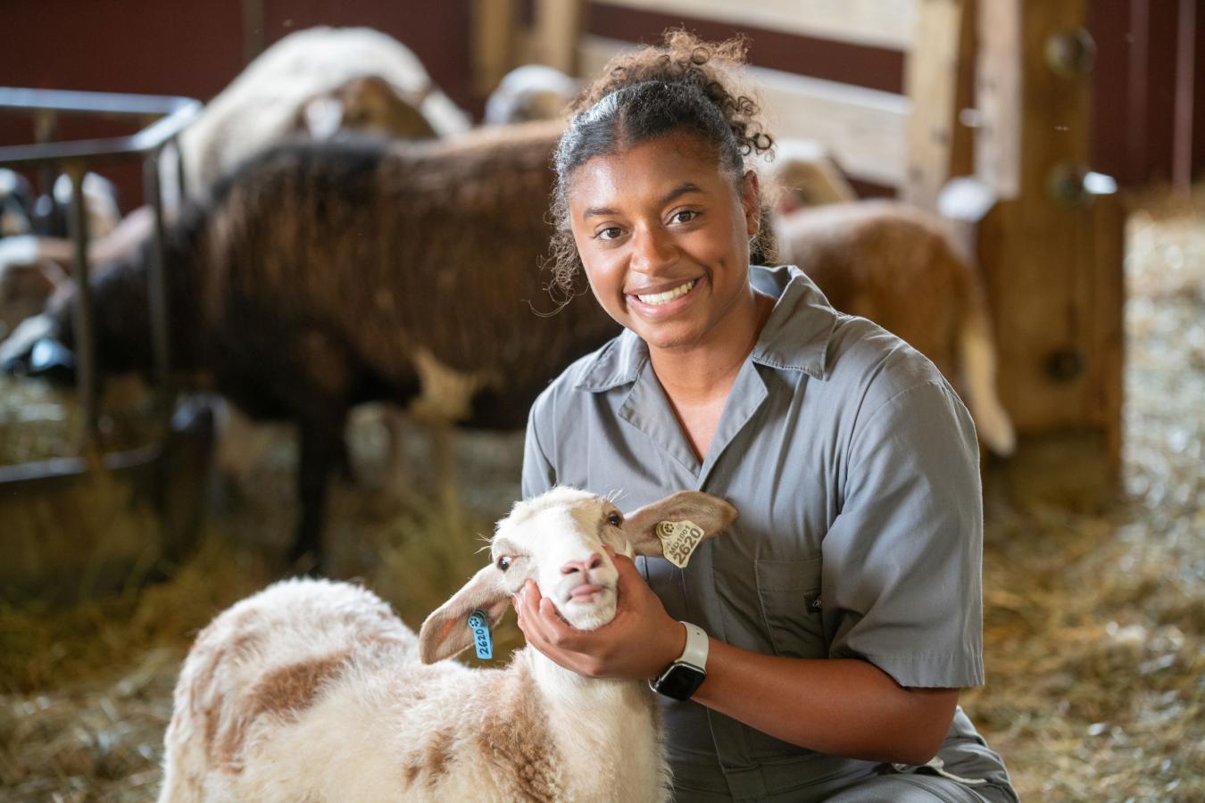 Student with a lamb at the Campus Farm