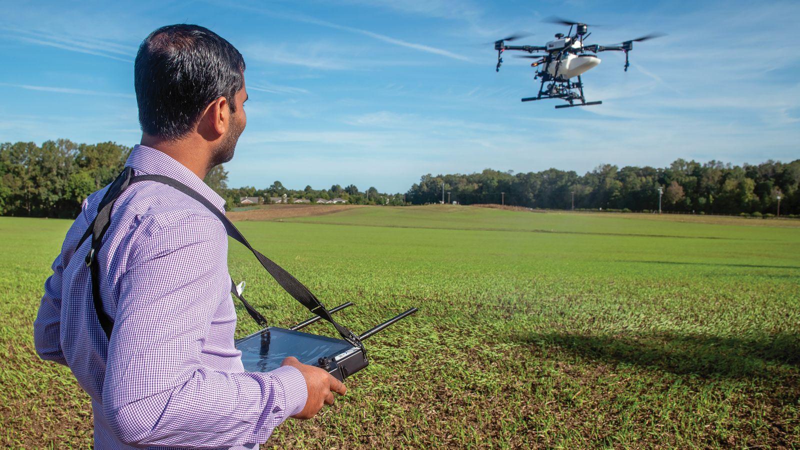 Hemendra Kumar flying a drone at a farm