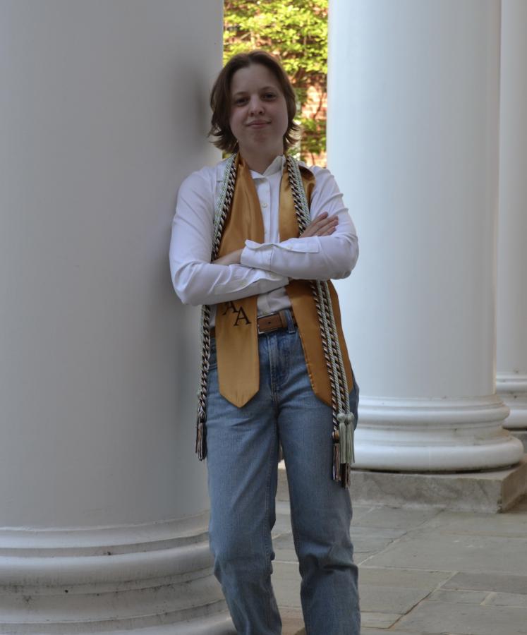 Student leaning proudly against the white column of a building at the University of Maryland - an iconic landmark seen throughout campus. 